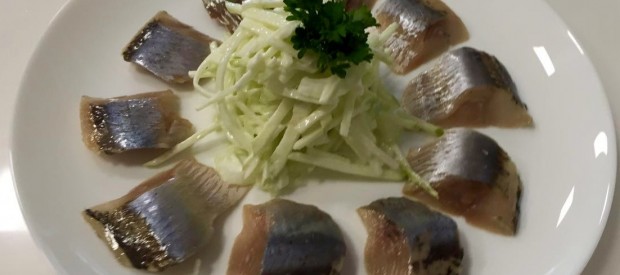 Закуска из слабосоленой сельди с яблоком, луком и сметаной.